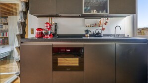 Une cuisine moderne équipée d’un lave-vaisselle, d’une machine à café et d’une bouilloire.