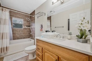 Un bagno moderno con vasca, servizi igienici e lavabo con specchio.