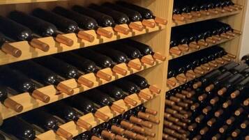 A wine cellar with wooden racks holding numerous wine bottles.