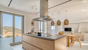 Uma cozinha moderna com uma ilha grande, armários de madeira e vista para o deserto.