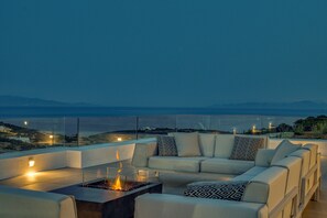 Vila superluxo, vários quartos, piscina particular, vista para o mar | Área de estar | Smart TV 65 polegadas com canais via satélite, TV, lareira