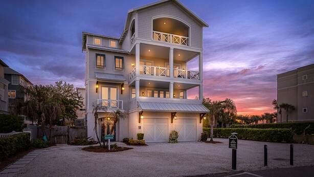 A multi-story building with a balcony on the second floor, a garage, and a sign indicating it is a resort. - Seahorse Villa! Amazing Ocean Views, Heated Pool, Private Elevator, Steps to Beach (Saint Simons Island)