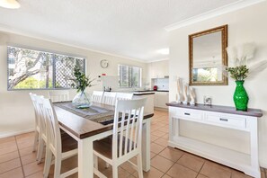Enjoy meals in this kitchen with a dining table and modern cabinetry.