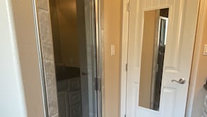A room with a sliding glass door leading to a closet, a white door with a mirror, and a black doormat on the floor. - Single Family Home - 52 BP (Laguna Vista)