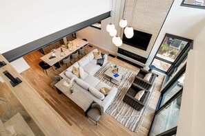 A modern living room with a sofa, dining table, and TV.