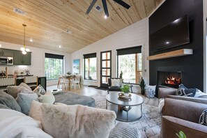 Relax in a cozy seating area with plush sofas and a large flat-screen TV, perfect for unwinding.
