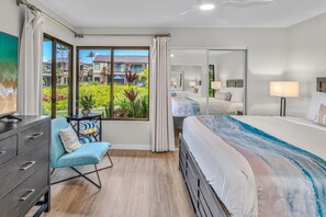 A hotel room with a large window, a bed, a desk with a chair, and a wardrobe. - Luxurious Oceanfront Condo at Wailea Elua Village - Unit 1201, Central AC, Wi-Fi (Kihei)