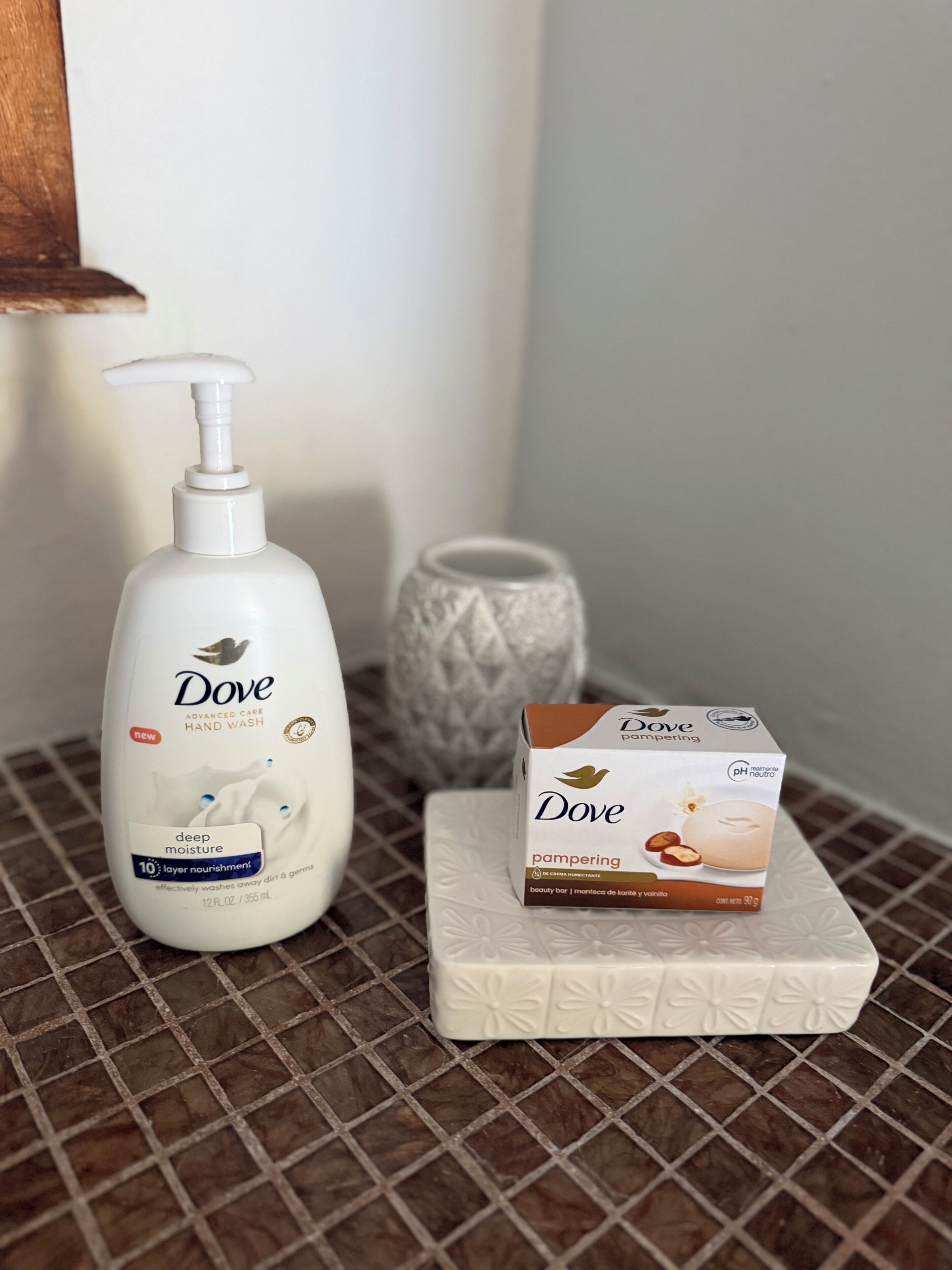 Dove hand wash and Dove pampering products on a tiled surface.