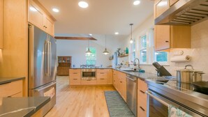 Una cocina moderna con armarios de madera, electrodomésticos de acero inoxidable y una isla central.