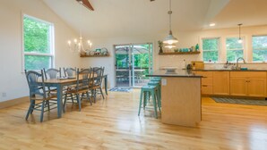 Una cocina amplia con suelo de madera, un comedor con sillas azules y una isla grande.