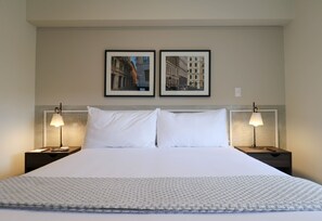A hotel room with a large bed, two bedside tables with lamps, and two framed pictures on the wall. - Wynwood Kennedy in Miraflores (Lima)