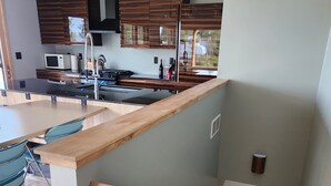 Una cocina moderna con armarios de madera, una isla central e iluminación colgante.