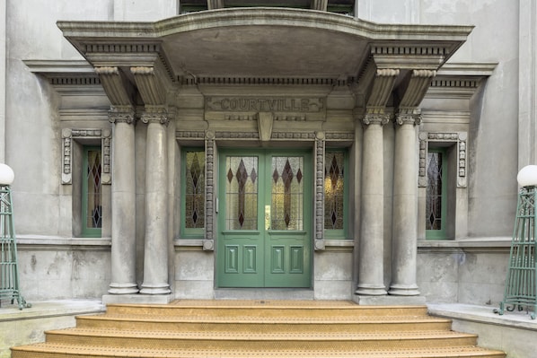 Experience the grandeur of Courville's stately entrance, featuring a beautifully crafted door and ornate columns.