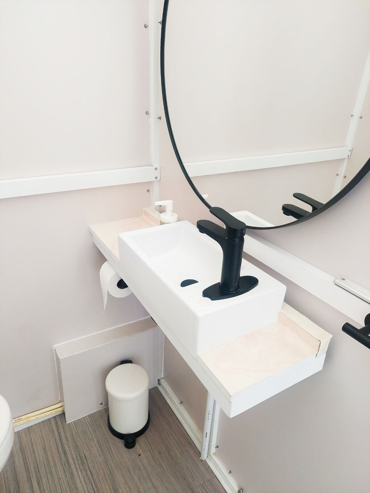 Une salle de bain avec un lavabo blanc, un miroir et des toilettes.