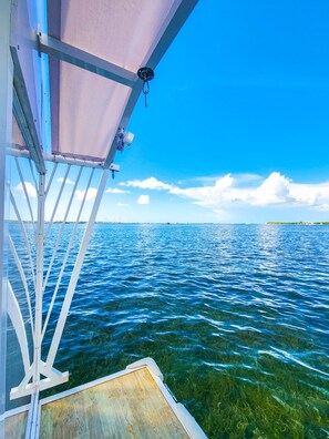 A boat with a clear view of the water and distant shoreline.
