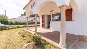 A white building with a wooden deck and arched columns. - Vacay L’Escala - Casa Los Pinos, pool and tranquility (l'Escala)