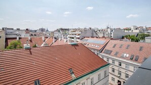 A cityscape with red-tiled rooftops and multiple buildings. - Lovely Mariahilf 2BR w/ Elevator, nr Shops & Cafes, by Blueground (Vienna)