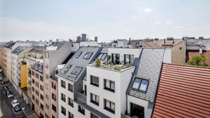 A row of modern buildings with flat roofs, some with skylights and balconies, and a street below. - Lovely Mariahilf 2BR w/ Elevator, nr Shops & Cafes, by Blueground (Vienna)