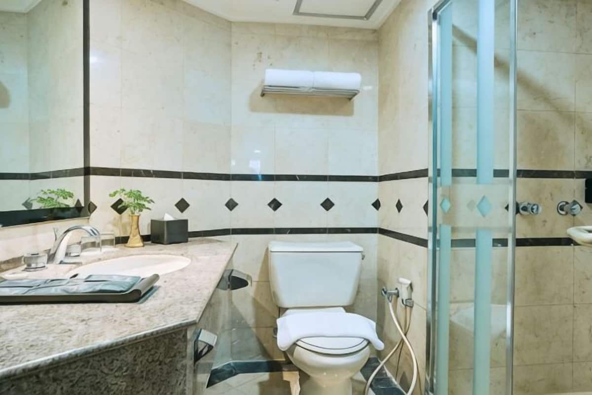 A bathroom with a sink, toilet, and shower.