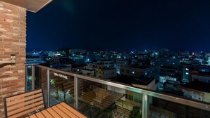 A night view from a balcony with a cityscape in the background. - Jecheon Hound Hotel (Jecheon)
