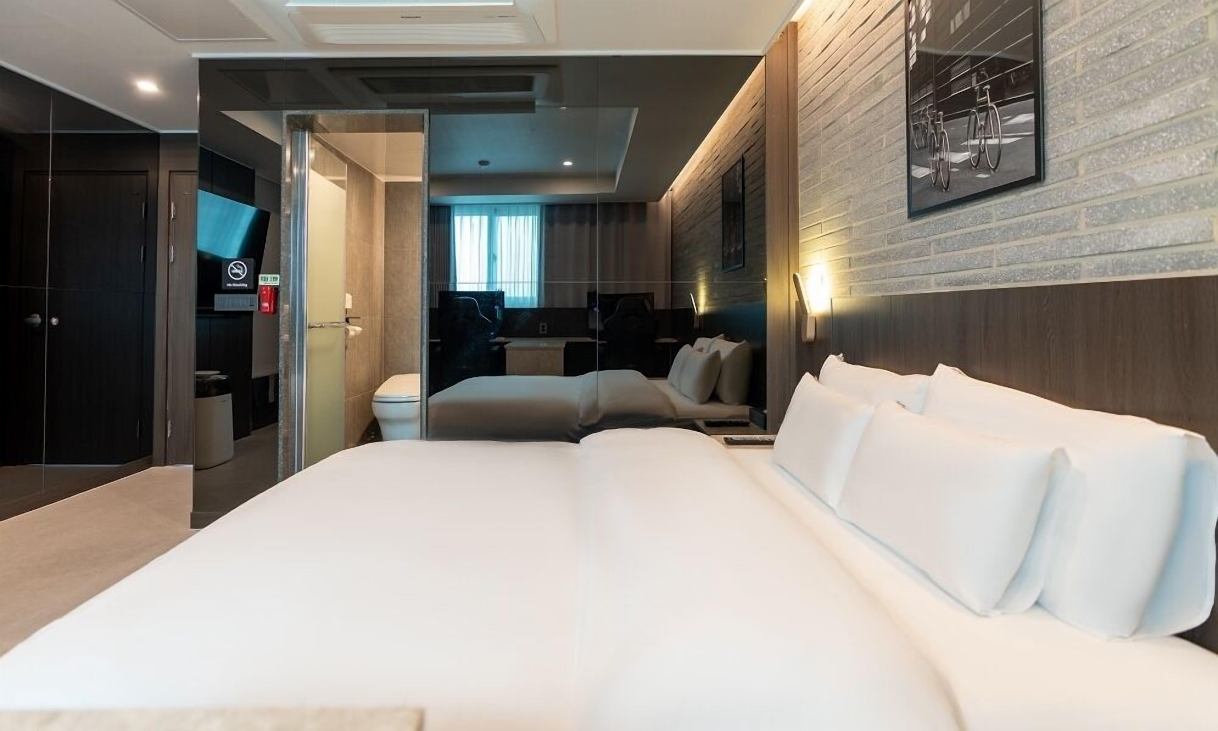 Een moderne hotelkamer met een groot bed, een zithoek en uitzicht op de stad.