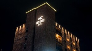 A tall building with a sign that reads "HOUND HOTEL" at the top. - Jecheon Hound Hotel (Jecheon)