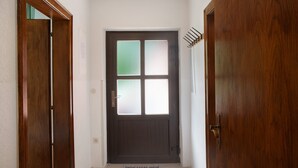 A wooden door with a frosted glass panel, a doormat with a design, and a coat rack to the right. - Apartment "Flying Hirsch" at Molltaler Appartements with Mountain View, Balcony & Wi-Fi (Stall)