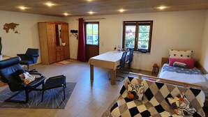 Una habitación con cama, escritorio, silla, armario y ventana.