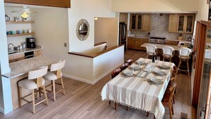 A spacious kitchen with wooden cabinets, a central island, and a dining area with a table set for four.