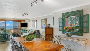Enjoy a spacious living area with a dining table, comfortable seating, and a large window offering a view of the outdoors.