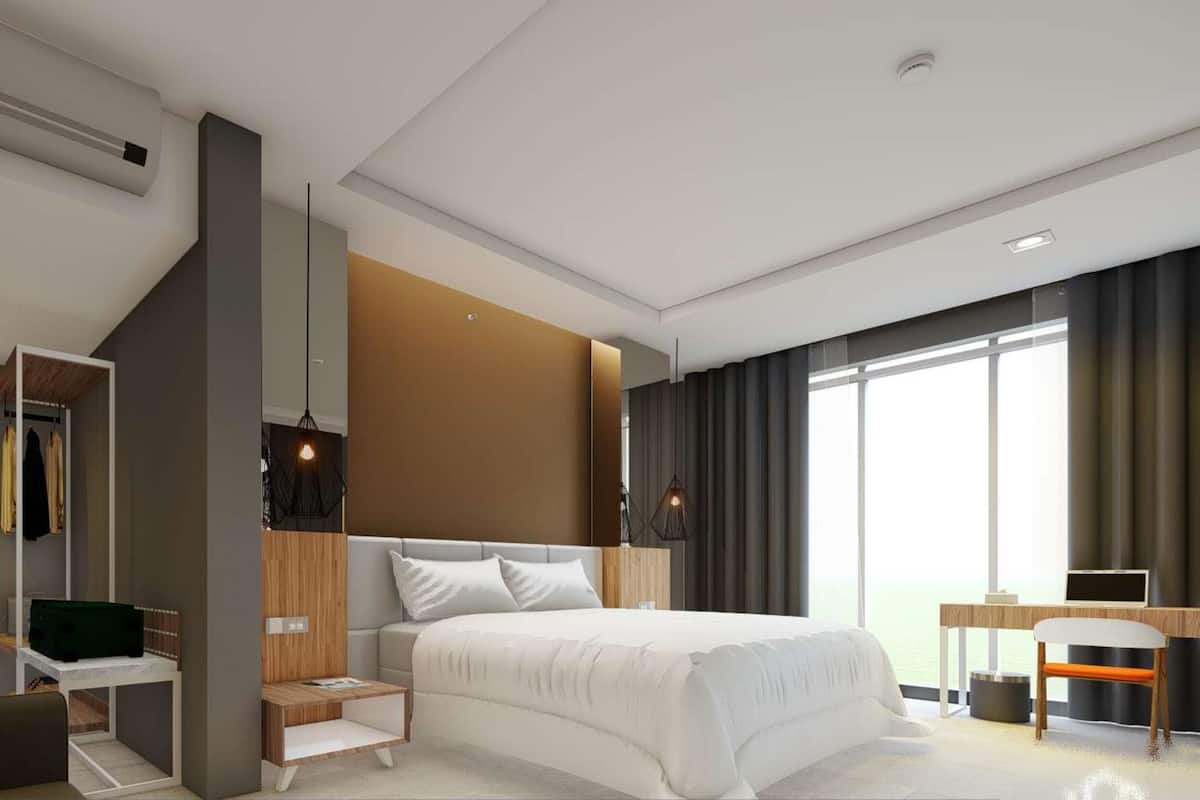 Ein modernes Hotelzimmer mit einem großen Bett, einem Schreibtisch und einem Kleiderschrank.