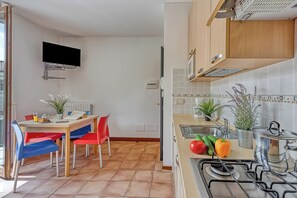 Une cuisine équipée d’une cuisinière, d’un évier et d’un coin repas avec des chaises et une table.