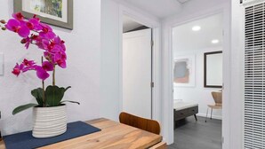 A reception desk with a wooden surface, a white vase with pink orchids, and a blue mat. - Mount Hermon Redwood Retreat! (Felton)