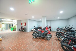 A spacious indoor area with multiple motorcycles parked. - YOUR HOME - 1BR Apartment 50m² (Thành phố Hồ Chí Minh)