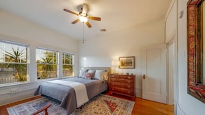 Une chambre à coucher avec un lit, une commode et un ventilateur de plafond.