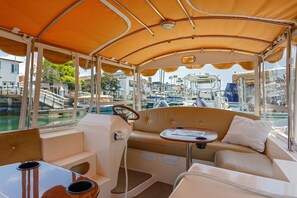 Relax in the boat's cozy seating area, complete with a table and comfortable seating for two.