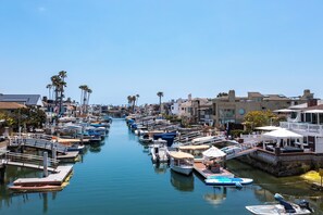 Boats docked along the marina, surrounded by buildings with balconies and flat roofs.