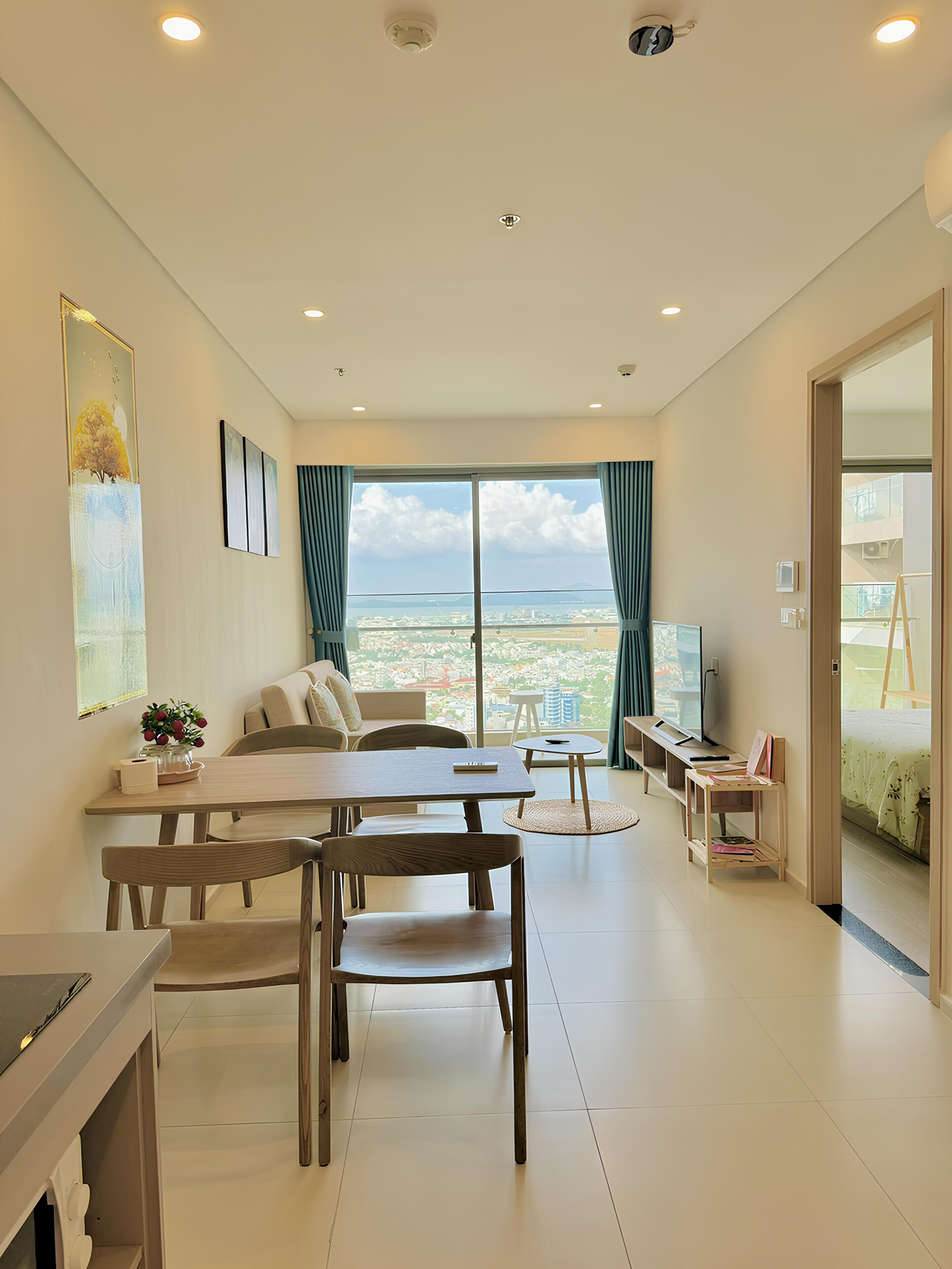 Una sala de estar moderna con comedor, ventanas amplias y vista a la ciudad.