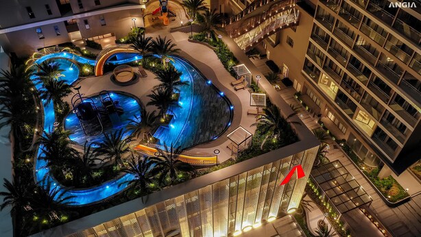 Una piscina en la azotea con múltiples fuentes y zonas de descanso, rodeada de palmeras y arquitectura moderna.