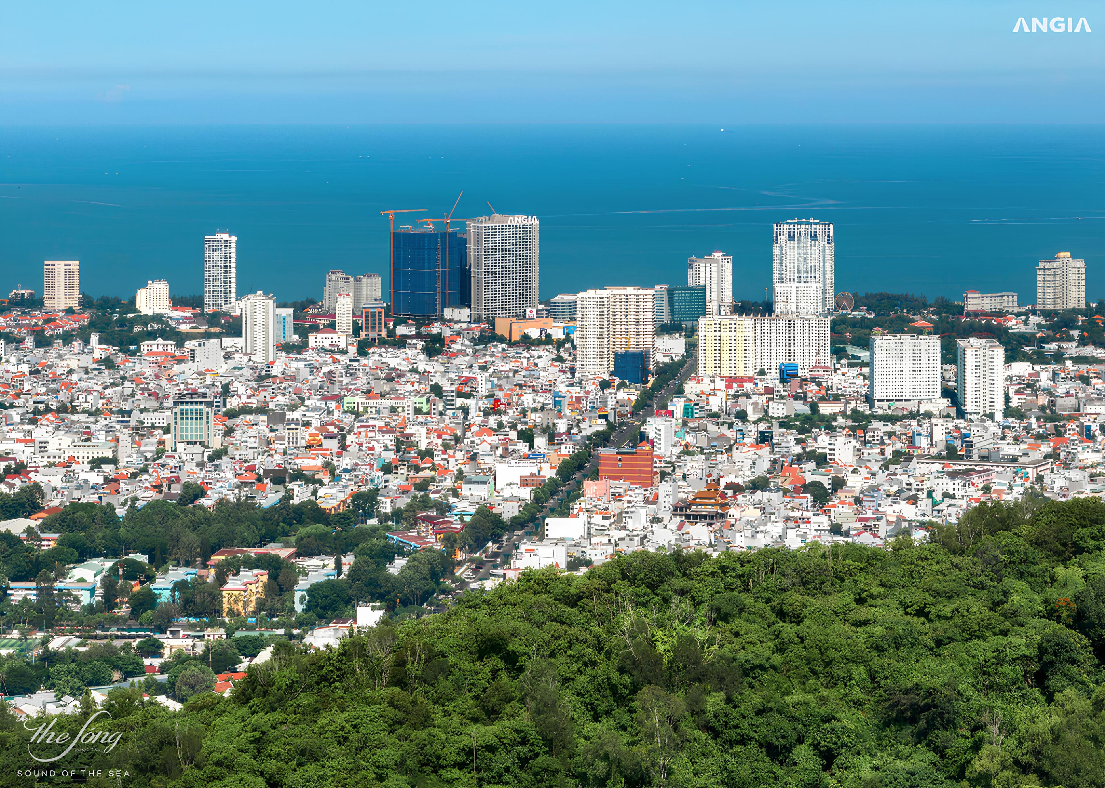 Un paysage urbain côtier caractérisé par une forte densité de constructions, notamment des immeubles de grande hauteur, ainsi qu’un mélange de bâtiments résidentiels et commerciaux.
