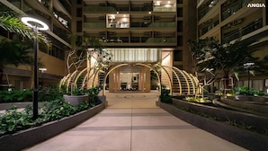 A modern hotel entrance with a central archway, surrounded by greenery and a well-lit pathway. - The Sóng Vũng Tàu - Shin's Apartment (Ho Chi Minh City)