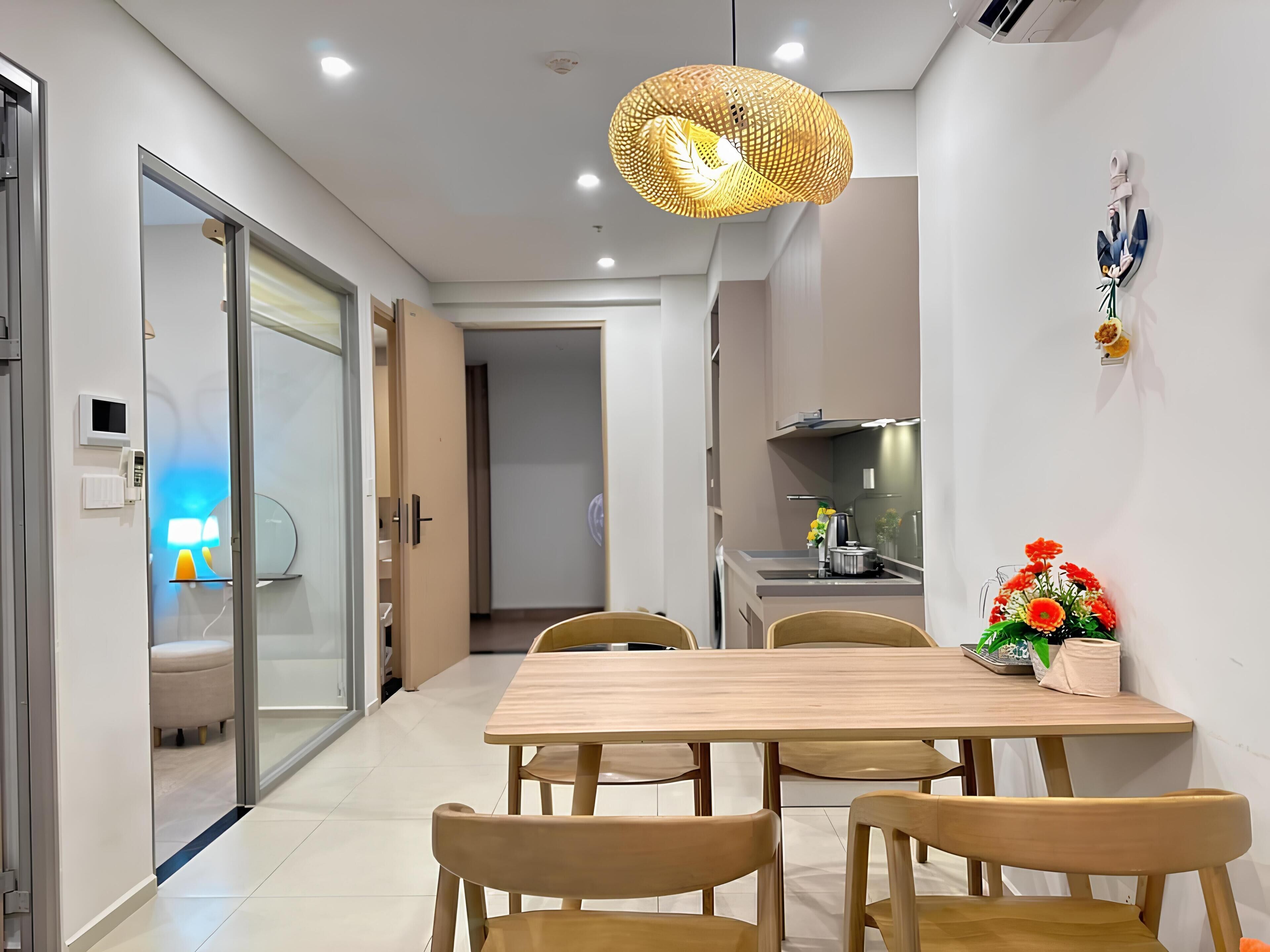 Une cuisine moderne avec une table et des chaises en bois, un luminaire suspendu et un petit coin repas.