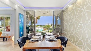 A dining area with a wooden table set for six, surrounded by black chairs. - Stunning 2BR/3Beds Lux Condo w/ Private Pool at Sunset 13 by Bocobay (Noord)