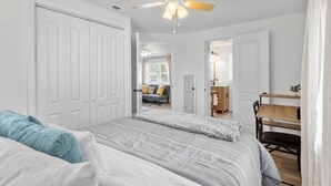 A bedroom with a bed, a desk, and a ceiling fan. - Charming, Private Abode: Serenity in Hopewell, VA! (Hopewell)