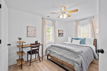 Master bedroom with queen bed, ceiling fan, closet space, desk and ensuite full bathroom.