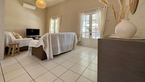 Une chambre à coucher avec un lit, une télévision, un bureau et une fenêtre avec des rideaux.