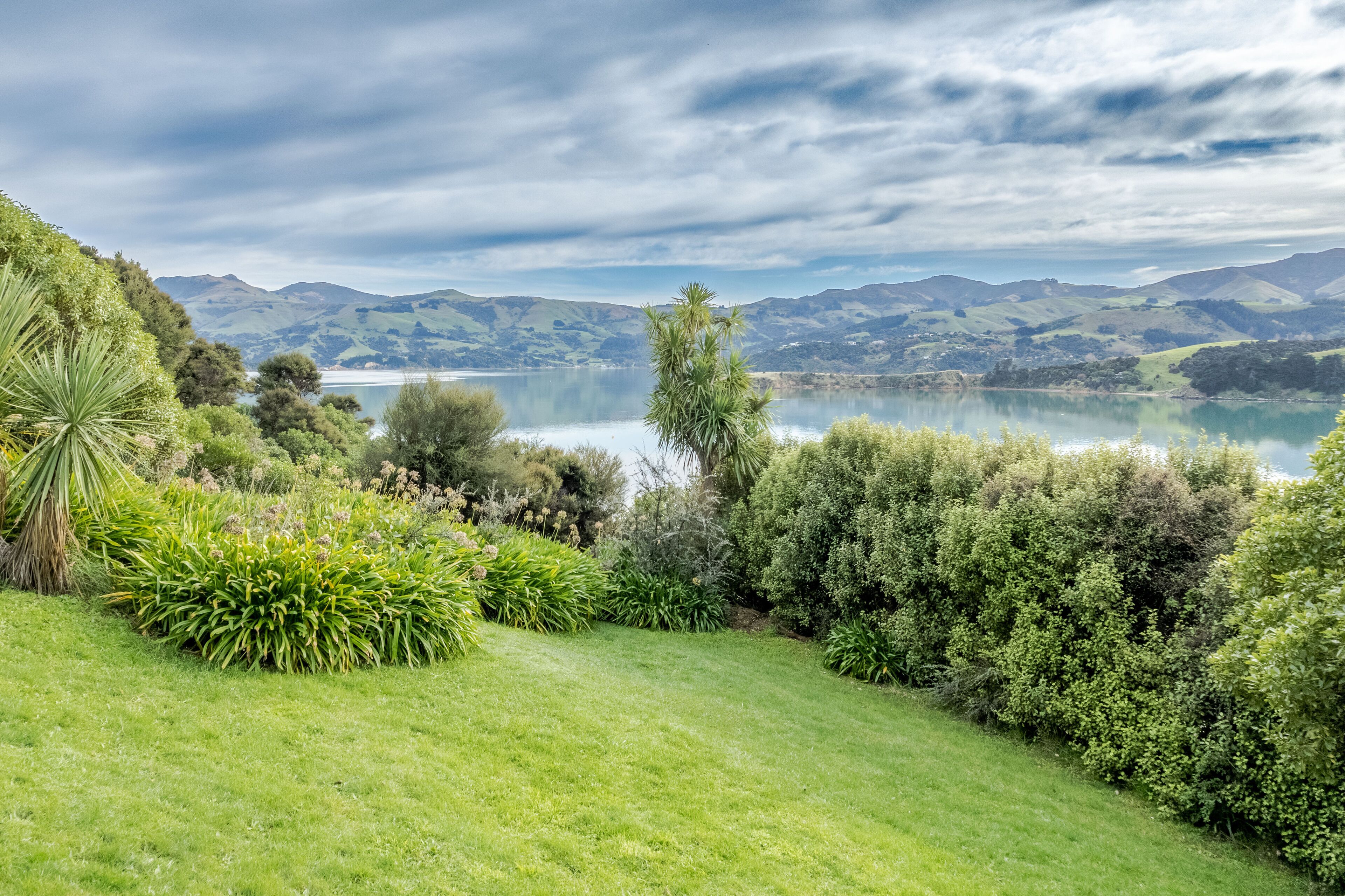 A lush, green landscape with a lake and mountains in the background.