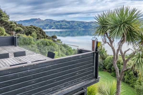 A deck with a view of a lake and mountains. - Birdsong Bliss - Takamatua Holiday Home (Takamatua)
