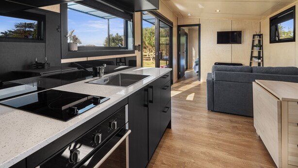 A modern kitchen with a large island, built-in appliances, and a view to the outdoors. - Peace in Paradise - Tokerau Beach Holiday Home (Tokerau Beach)