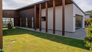 Ein modernes Gebäude mit flachem Dach, großen Fenstern und einer Garage.
